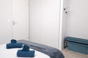 a bedroom with a bed with blue towels on it at T3 centre La Teste-de-Buch Terrasse 2 parkings Wi-Fi fibre 4 pers in La Teste-de-Buch