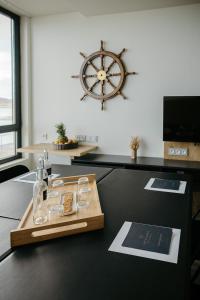 a table with a tray of glasses and a large clock at Le Nautica Hôtel in Perros-Guirec