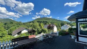 a patio with a bench and a table and chairs at Siebenglück - 4 FeWo's mit SommerCard in Winterberg