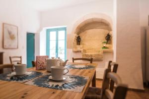 a dining room with a wooden table with cups on it at Château Croix Beauséjour "Maison du Vigneron" in Montagne +15 photos