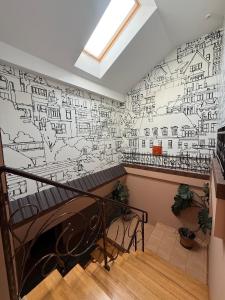 a room with a wall with a mural of cities at Troyanda in Radyvyliv