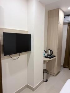 a flat screen tv on a wall in a hotel room at Tresor Hotel in Cochin