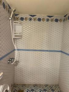 a bathroom with a white and blue tiled wall at Merzouga Roms in Merzouga +59 photos