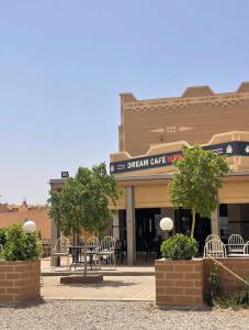 a building with chairs and tables in front of it at Merzouga Roms in Merzouga