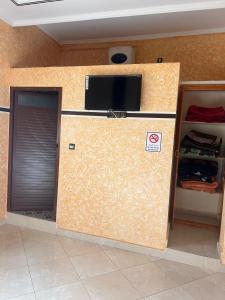a wall with a flat screen tv on top of it at Merzouga Roms in Merzouga