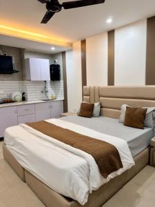 a bedroom with a large bed and a kitchen at Halo Haven in Dehradun