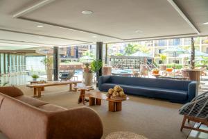 a living room with a blue couch and tables at Afago Mareiro Hotel in Fortaleza