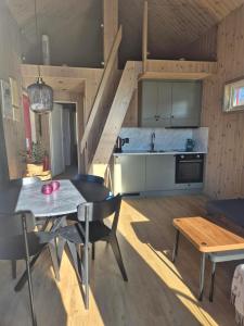 a kitchen and living room with a table and chairs at Måvikens havsstugor in Måviken +19 photos