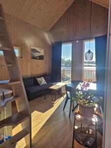 a living room with a couch and a table at Måvikens havsstugor in Måviken
