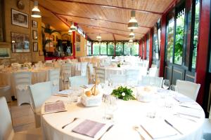 a dining room with white tables and white chairs at Hotel Valganna - Tre Risotti in Valganna