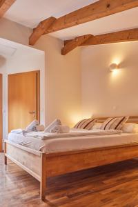 a large bed in a room with wooden floors at I AM HOTELS Graz-Seiersberg in Graz