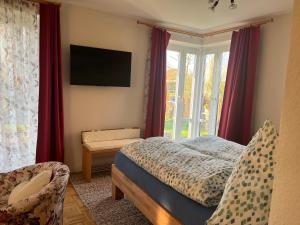 a bedroom with a bed and a television on the wall at PusteBlume in Bückeburg