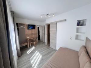 a living room with a couch and a desk at Hotel Kriemhilde in Worms