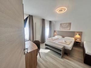 a hotel room with two beds and a desk at Hotel Kriemhilde in Worms