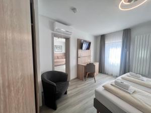 a room with a bed and a chair and a desk at Hotel Kriemhilde in Worms