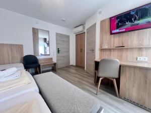 a hotel room with a bed and a tv on a wall at Hotel Kriemhilde in Worms +9 photos