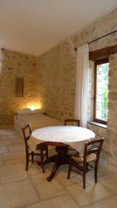 a room with a table and a bed and a bedroom at La Ferme de la Condamine in Saint-André-de-Rosans