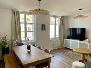 a living room with a table and a tv and a table and chairs at Bohemian Rhapsody- Hyper centre Compiègne in Compiègne