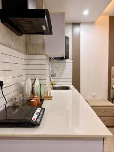 a kitchen counter top with a remote control on it at Halo Haven in Dehradun