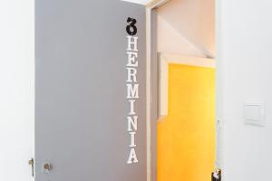 a hallway with a yellow door and a sign that reads excellence at Casas de Fado in Lisbon