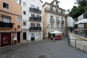 a woman standing in an alley in front of a building at Casas de Fado in Lisbon +17 photos