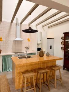 a kitchen with a counter with stools and a sink at Fronteira in Fronteira