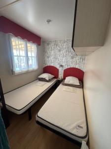 a small room with two beds in it at MH Camping la plage - MarieVa in Mimizan-Plage +10 photos
