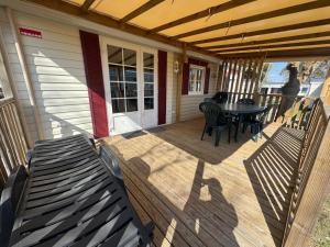 a wooden deck with a table and chairs on a house at MH Camping la plage - MarieVa in Mimizan-Plage