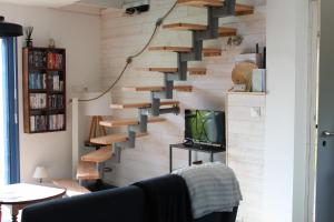 a wooden staircase in a living room with a tv at Portec la mer et le sentier côtier à pied in Moëlan-sur-Mer