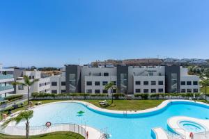 an apartment with a large swimming pool in a building at Casa Cala Serena in Mijas