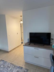 a living room with a flat screen tv on a dresser at Résidence inside in Ferney-Voltaire