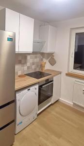 a kitchen with white cabinets and a stove top oven at DEBSI vacation rental in Bad Windsheim