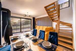 a dining room with a table and chairs and a staircase at Chalety v Pieninách in Červený Kláštor