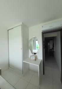 a white room with a mirror and a table at Flat Vila Monte Castelo in Gravatá +26 photos