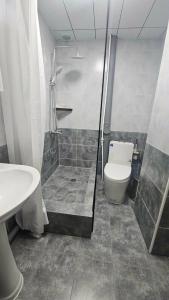 a bathroom with a shower and a toilet and a sink at Очир зочид буудал in Dalandzadgad