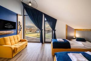 a hotel room with two beds and a couch at Chalety v Pieninách in Červený Kláštor +60 photos