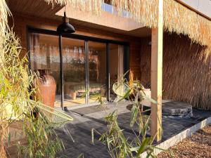a house with a patio with a large glass door at Refuge des Dunes in Marck