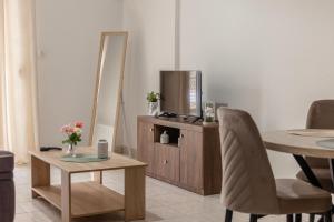 a living room with a tv and a table with chairs at Pineios View New Apartment in Larisa