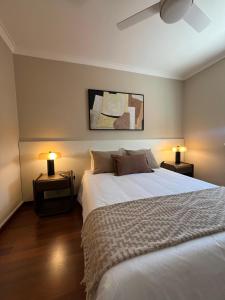 a bedroom with a white bed and two lamps at Private Room in Old Town in Viana do Castelo