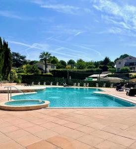 a large swimming pool with chaises and chairs at Eden Cottages - Premium Cottage avec Piscine in Antibes