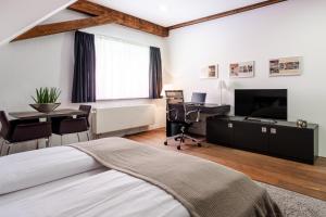 a bedroom with a bed and a desk and a television at Buhlsche Mühle in Ettlingen
