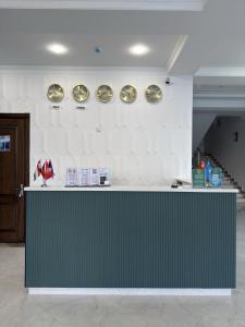 a counter in a room with plates on the wall at Munir Hotel in Chilanzar +23 photos