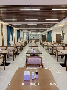 a dining room with tables and chairs in a room at Munir Hotel in Chilanzar