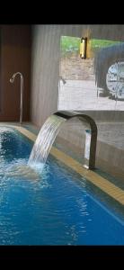 a water fountain in a swimming pool at Munir Hotel in Chilanzar