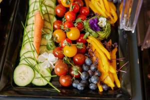 a tray filled with fruits and vegetables on a table at I AM HOTELS Graz-Seiersberg in Graz