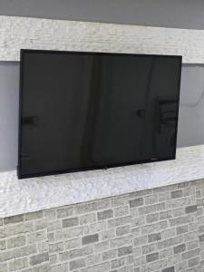 a flat screen tv on a brick wall at Smart Apartament in Brăila