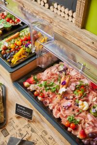a buffet with many different types of food on display at I AM HOTELS Graz-Seiersberg in Graz
