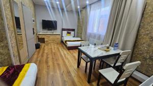a room with two beds and a table and chairs at Очир зочид буудал in Dalandzadgad