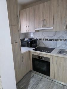 a kitchen with wooden cabinets and a stove top oven at Smart Apartament in Brăila