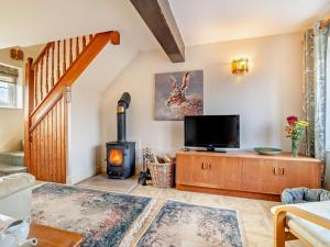 a living room with a tv and a wood stove at 1 Bed in Sherborne oc-93804 in Yetminster